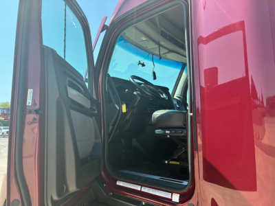 Kenworth T680 cab interior visible through open door; driver seat and steering wheel seen; maroon exterior; interior dashboard area partially visible
