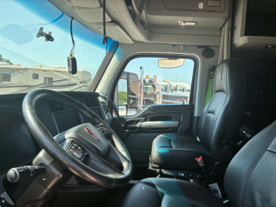 Kenworth T680 truck interior cabin view with steering wheel and driver's seat in view.