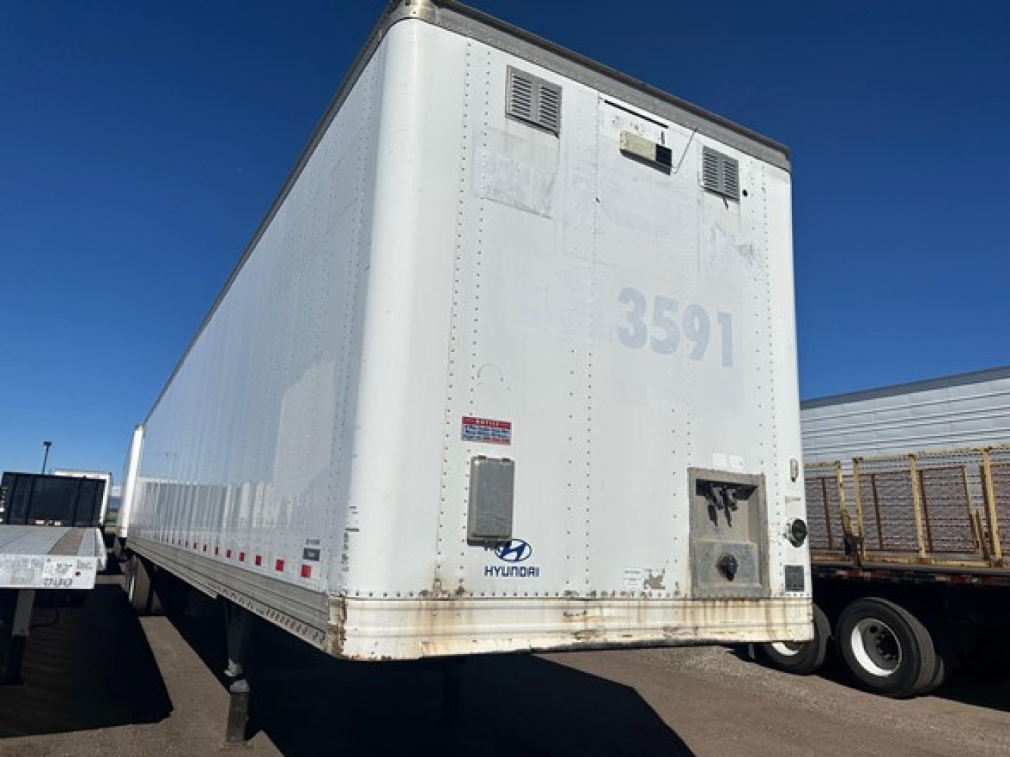 Hyundai 53' dry van trailer rear view with number 3591 and small access door, undercarriage and wheels visible.