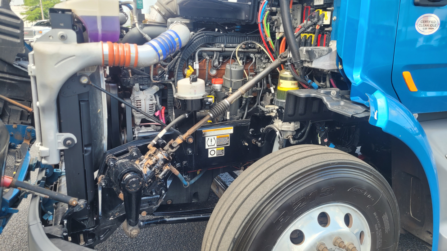 Peterbilt 579 engine bay and front wheel area with exposed components and wiring.