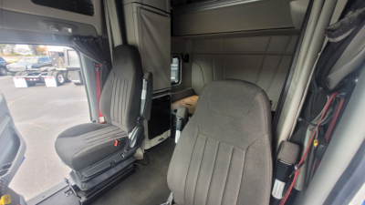Peterbilt 579 truck cab interior showing driver seat and passenger seat with center console and sleeper area.