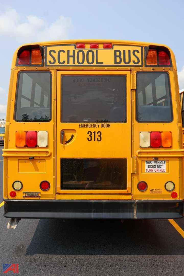 Rear view of a yellow 2014 Freightliner Thomas Saf-T-Liner school bus showing emergency door and bus numbers 313.