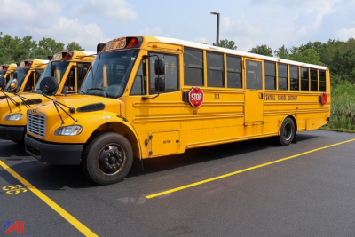 Yellow Freightliner Thomas Saf-T-Liner school bus side view showing stop sign and Central School District markings.