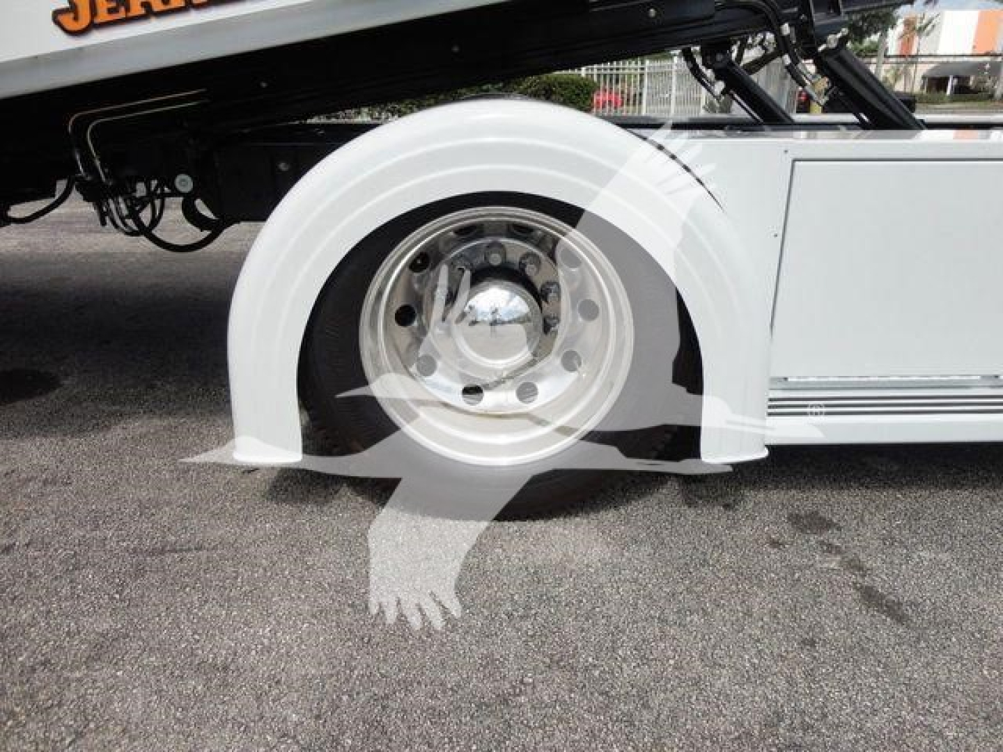 Wheel well of a 2026 Mack MD6 rollback truck showing white fender, polished alloy wheel and black undercarriage components.