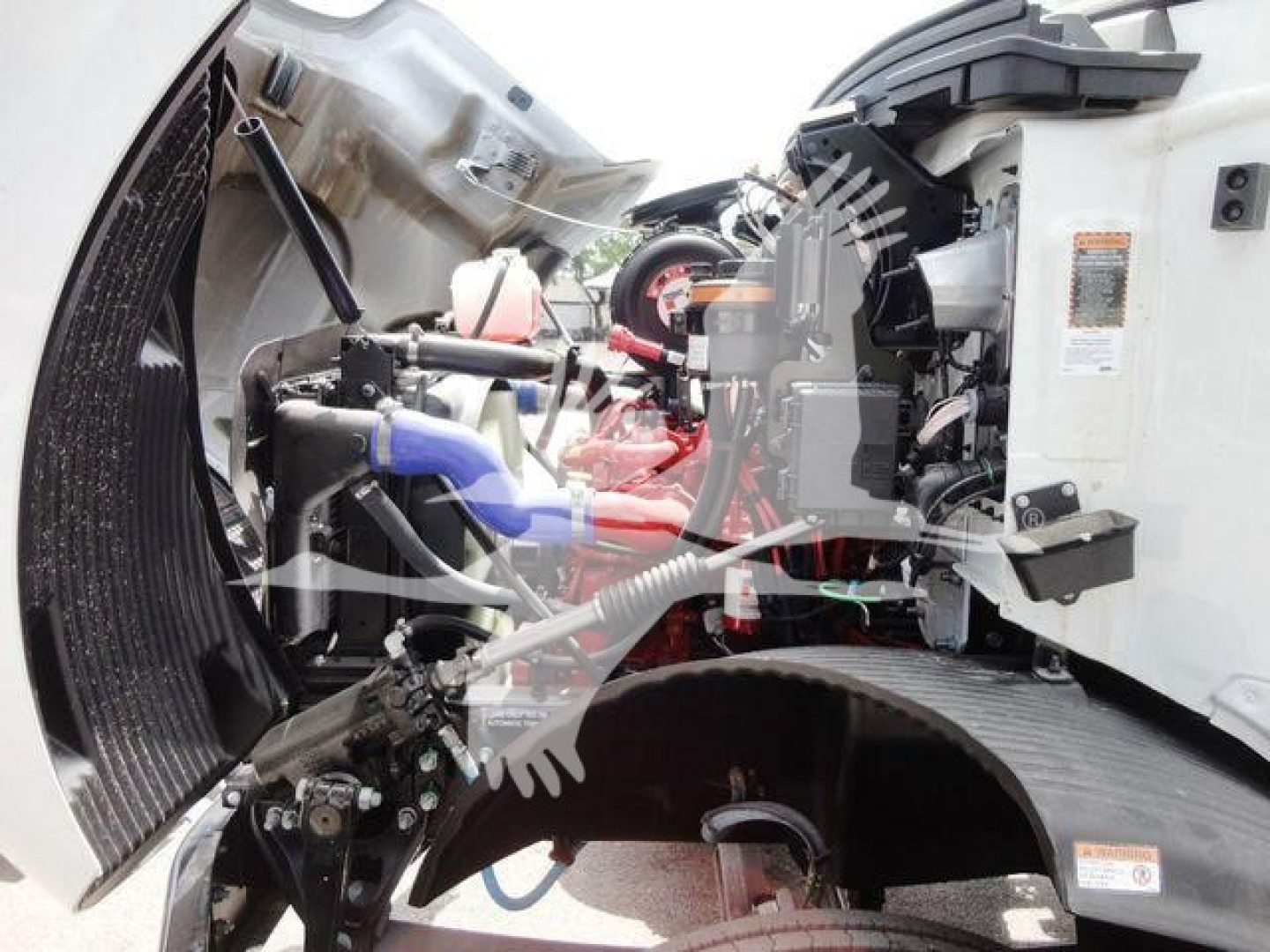 Mack MD6 engine bay showing diesel engine with red components, blue hoses, exposed wiring, and diagram label on the side panel.