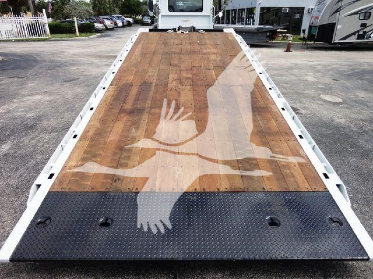 Flatbed truck deck on a 2026 Mack MD6 rollback unit showing wooden platform and black non-slip ramp area at the front.