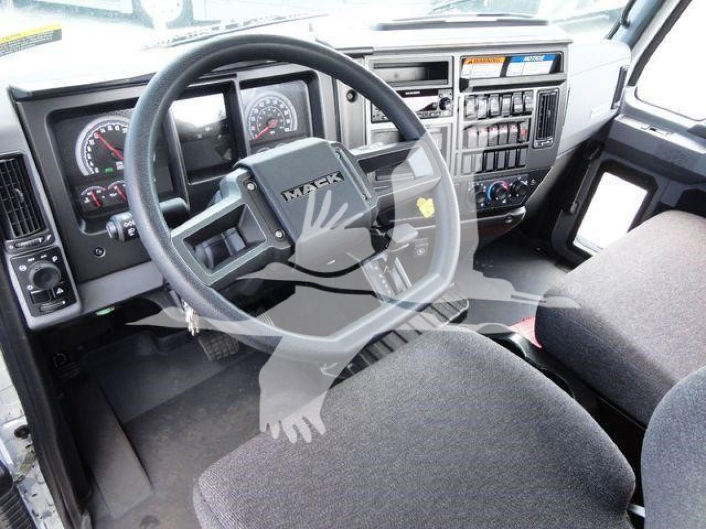 MD Series Mack truck interior showing steering wheel with MAR label, instrument cluster, and dashboard controls.