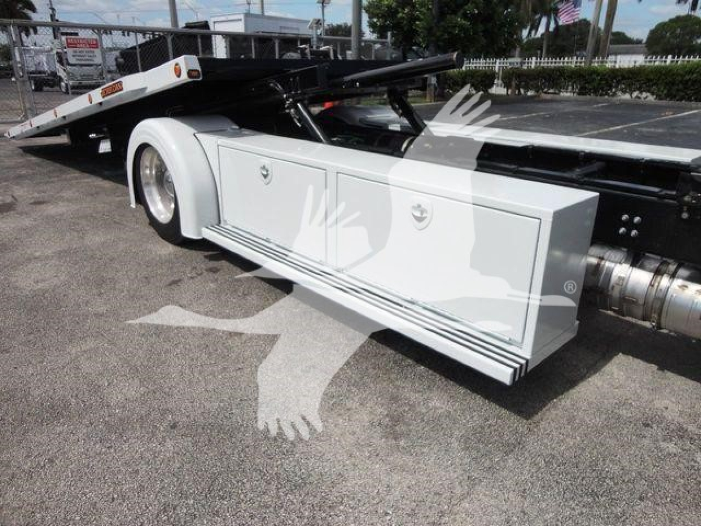 Rollback tow truck side panel with storage drawers and hydraulic bumper in view on white Mack MD6 chassis.