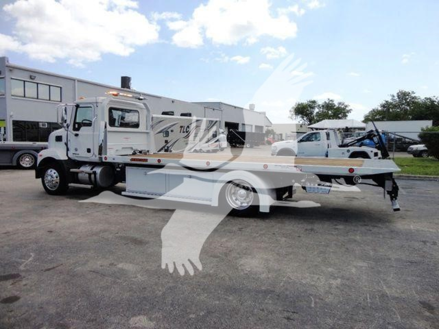 MD-6 rollback truck on lot showing Mack MD6 with flatbed and towing arm in side view
