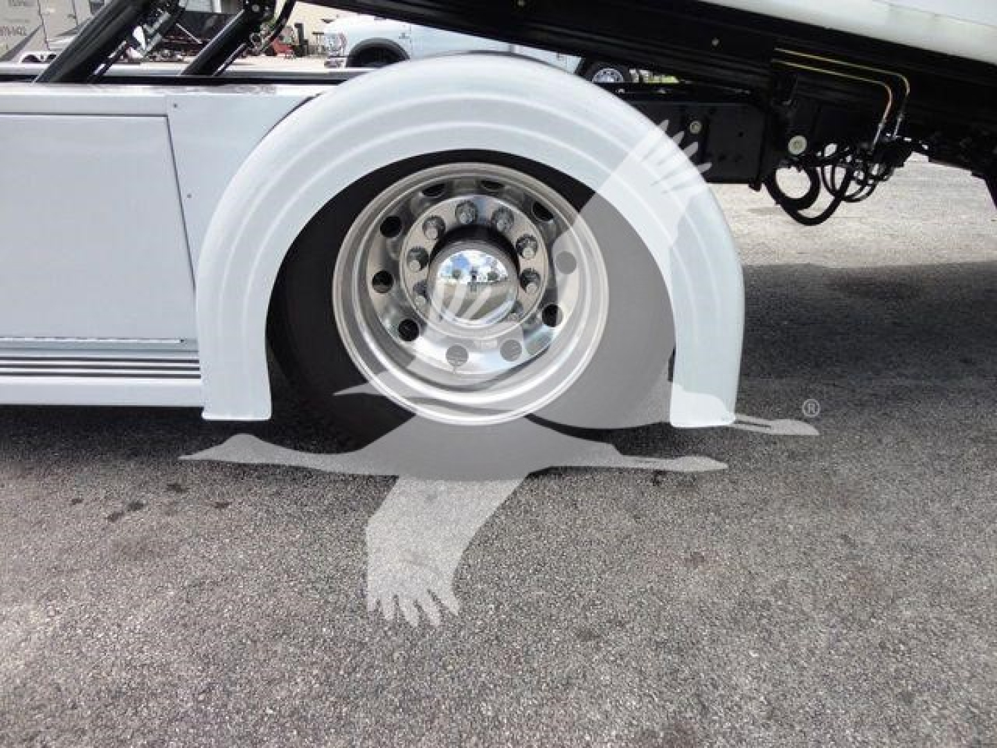 Mack MD6 rollback truck wheel and fender view showing polished wheel, white wheel arch, and undercarriage components.