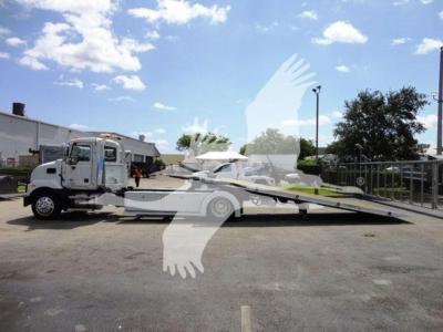 MD6 rollback tow truck with flatbed in service yard showing extended tow bed and cab side profile.