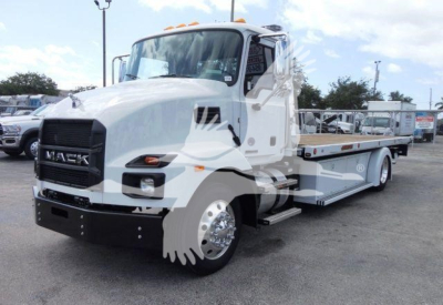 Mack MD6 rollback truck showing front grille with Mack emblem and flatbed/wheel-lift configuration.