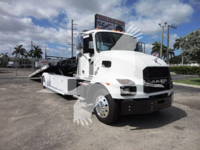 MD6 Mack rollback truck in service bay showing front and side view with white cab and flatbed.