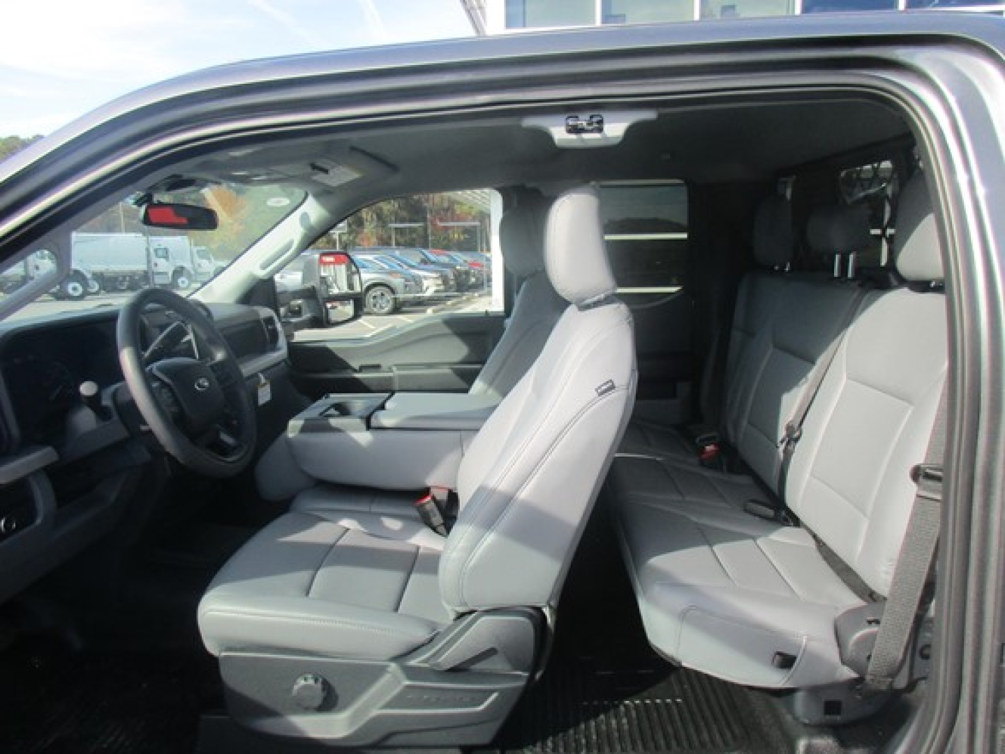 Ford F-350 Super Duty interior showing front captain seat and rear bench seats with light gray upholstery.