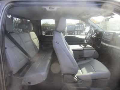 Truck interior showing front row of seats and dashboard; light gray upholstery.