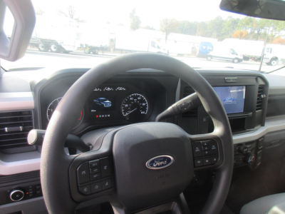 Ford F-350 interior steering wheel and dashboard with digital gauge cluster and infotainment screen.