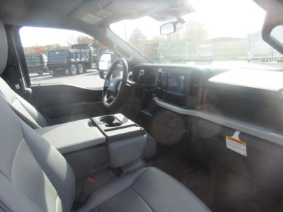 Ford F-350 Super Duty interior view showing front seats, dashboard, steering wheel, and center console in a new flatbed truck.