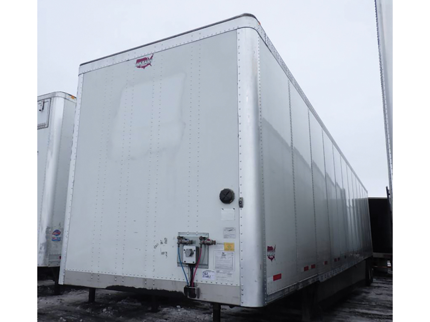 Wabash DuraPlate van trailer showing front corner with hitch and certification labels.
