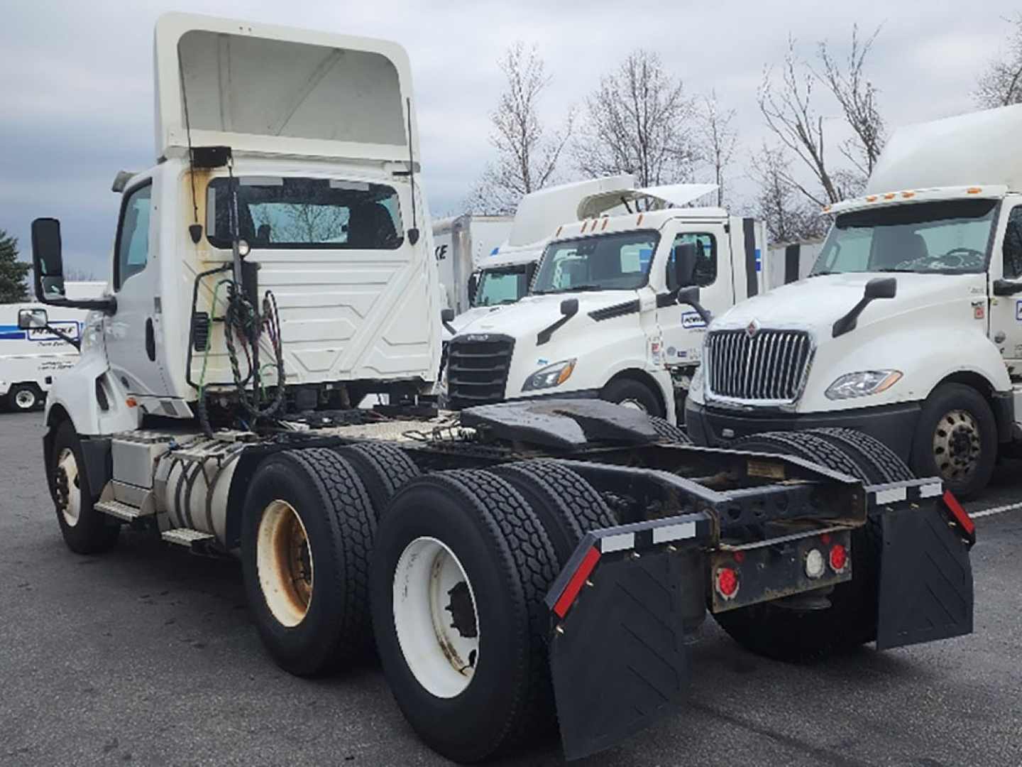 Truck chassis and cab of a white 2018 International LT625 in a lot, rear view showing dual rear axles and fifth wheel area.