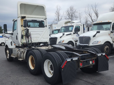Truck chassis and cab of a white 2018 International LT625 in a lot, rear view showing dual rear axles and fifth wheel area.