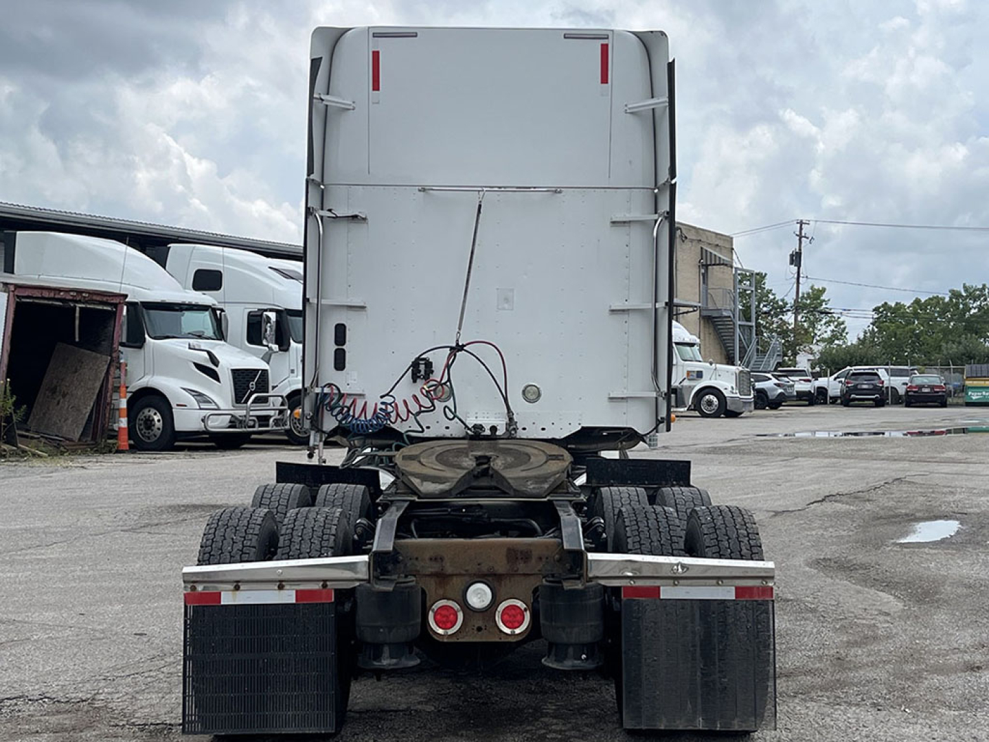 Rear view of a Freightliner Coronado truck tractor showing fifth wheel and dual rear axles with mud flaps and taillights.