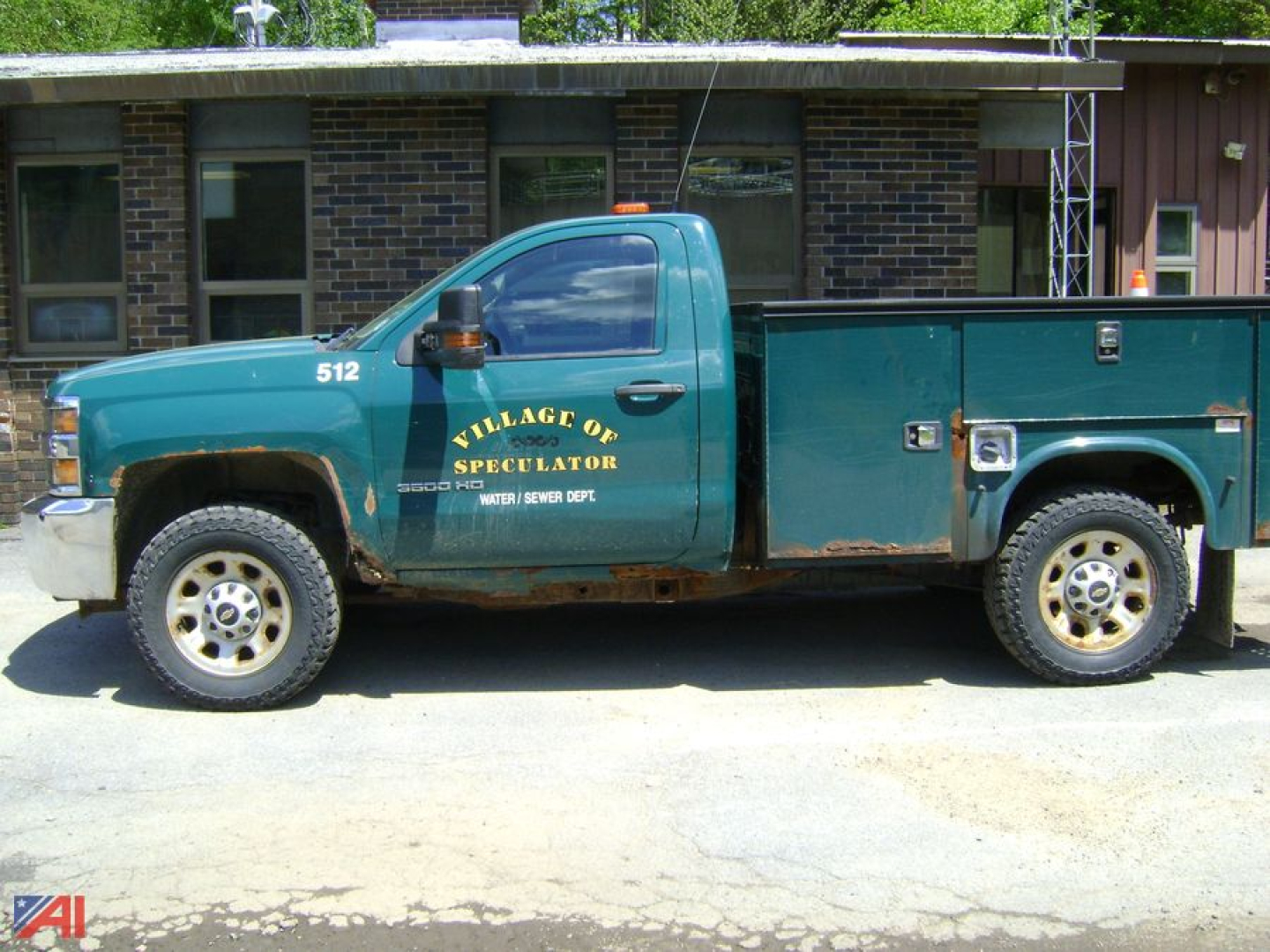 Chevrolet Silverado 3500HD utility body pickup with plow, teal-green color, service decal Village of Speculator, side view showing multiple compartments