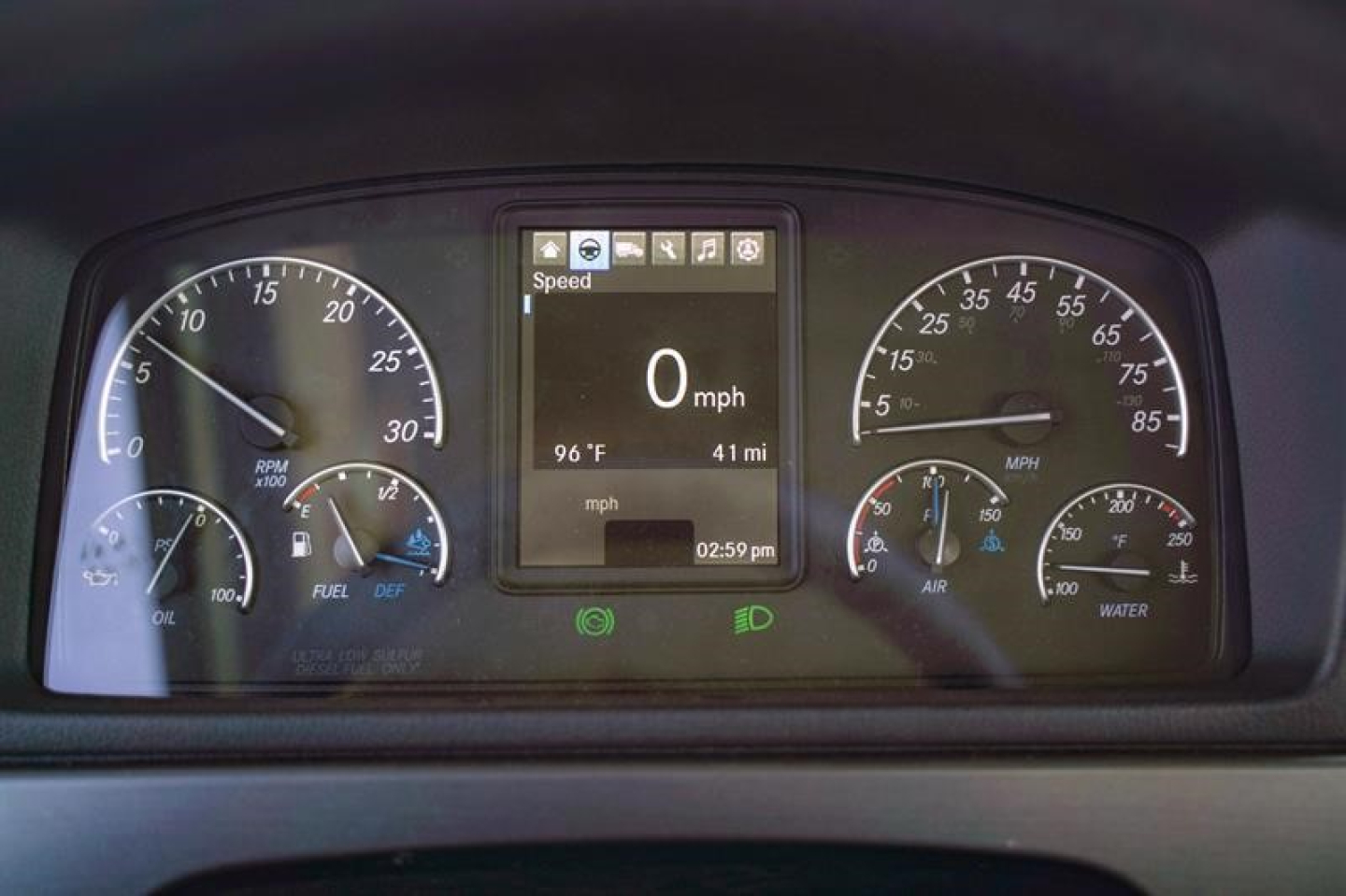 Dashboard of a Freightliner 114SD showing digital speedometer at 0 mph, with gauges for RPM, fuel, oil pressure, air, coolant, and parameters on center display.