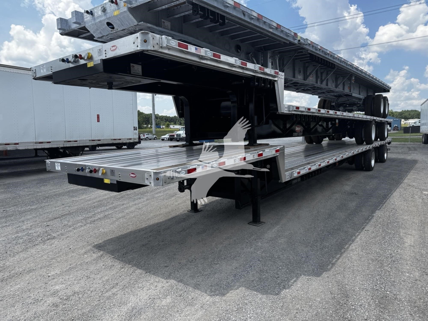 Trailer deck showing a flatbed combo trailer with multiple levels and support legs in an open lot.