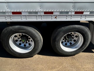 Dual rear wheels of a Great Dane refrigerated trailer with metal side panels and rivets.