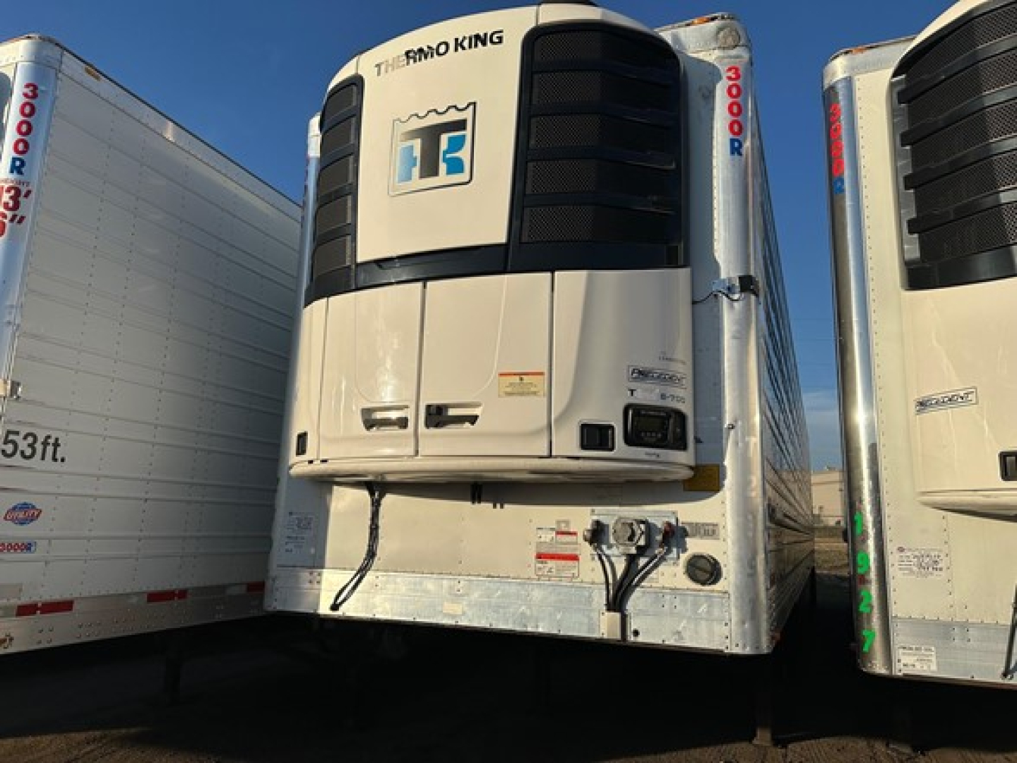 Reefer trailer front view with Thermo King unit mounted on front of white trailer doors and side skirts visible