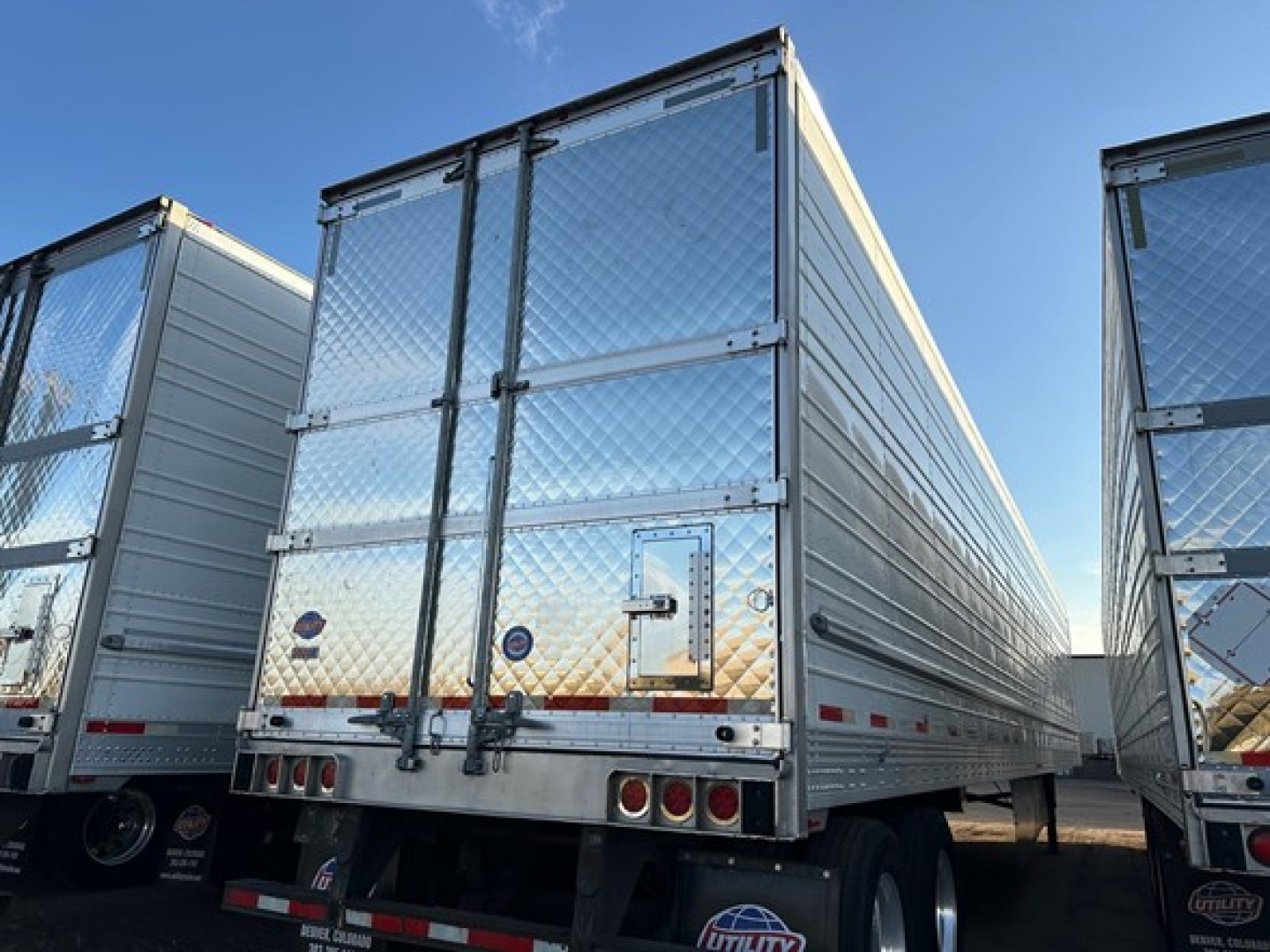 Utility reefer trailer showing rear doors and reflective diamond plate panels.