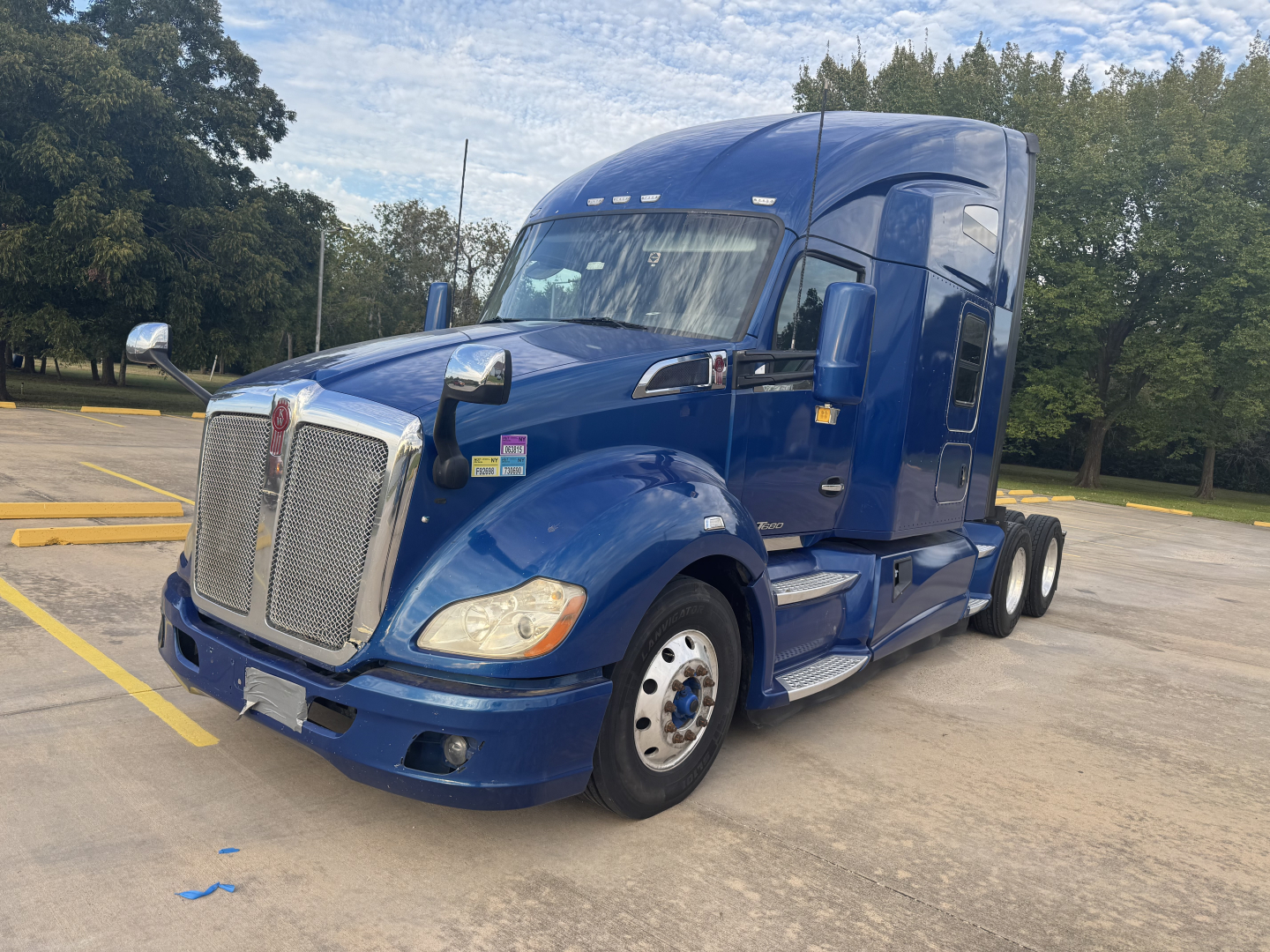 Peterbilt 579 tractor in blue, front three-quarter view, large grille, sleeper cab, dual rear axles, chrome accents and side steps.