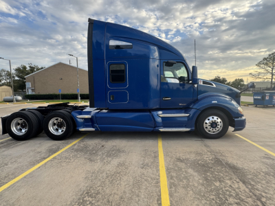 Peterbilt 579 long-hood tractor in blue, side profile view showing sleeper cab and dual rear axle configuration.