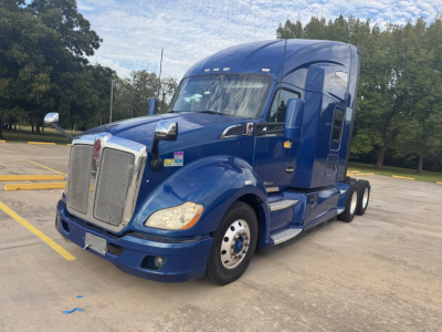 Peterbilt 579 tractor in blue, front three-quarter view, large grille, sleeper cab, dual rear axles, chrome accents and side steps.
