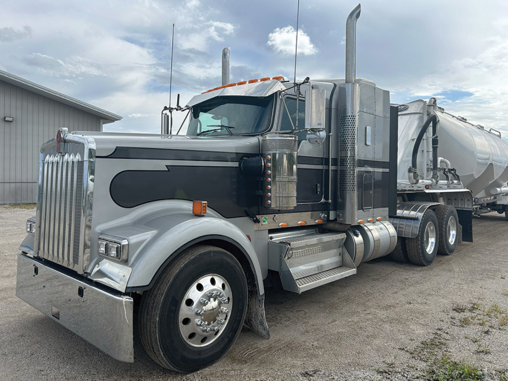 Kenworth W-900L AeroCab truck in profile view showing chrome grille, dual stacks, fuel tanks, and a tanker trailer attached.