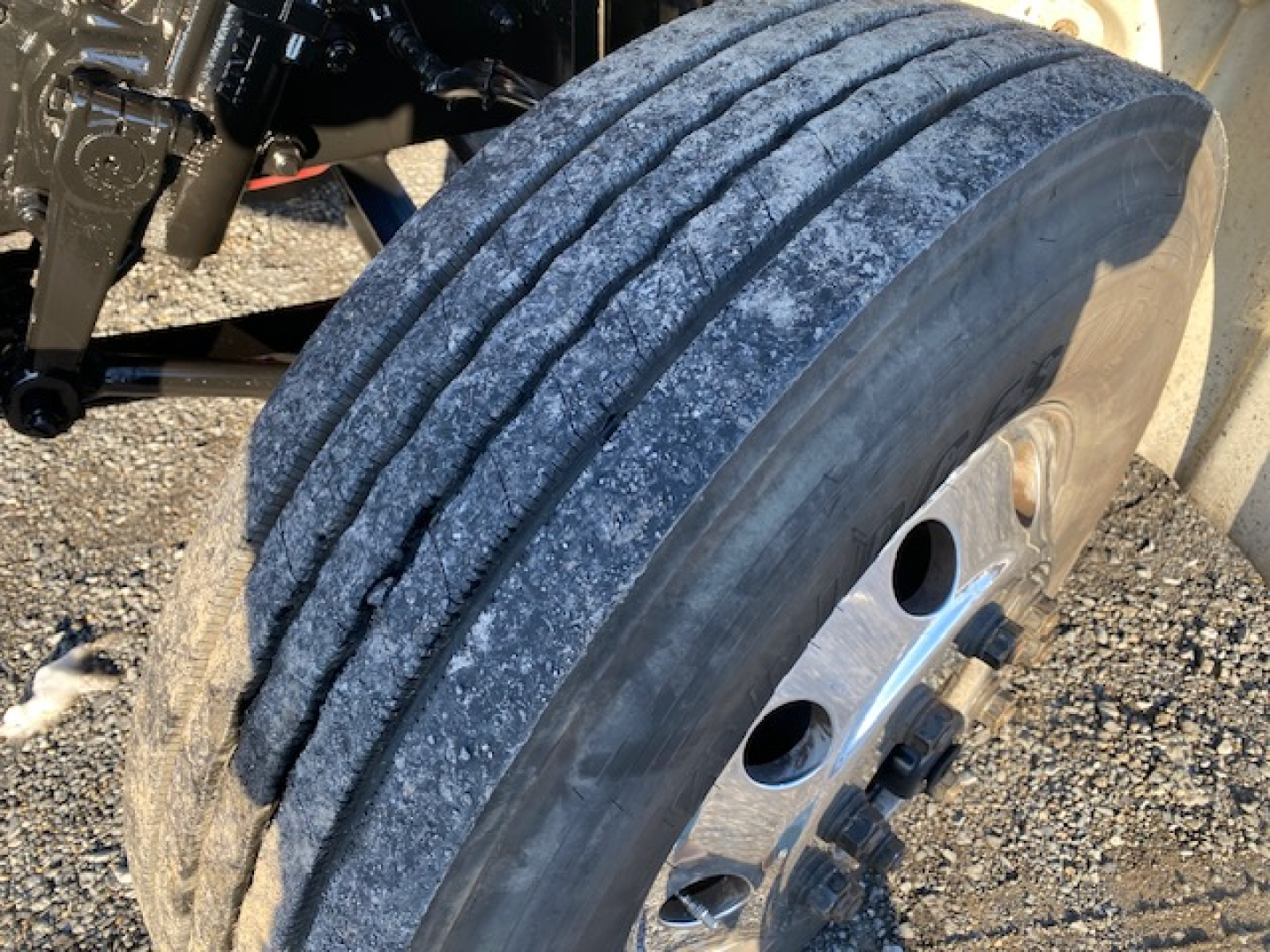 Freightliner M2-106 front wheel showing tire treads and hub with inner components visible.