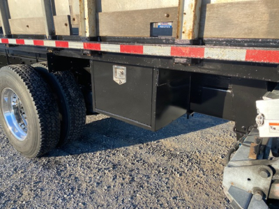 Freightliner M2-106 underbody toolbox and flatbed with dual rear tires visible.