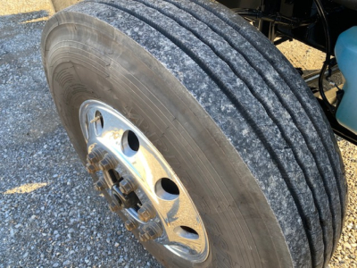 Freightliner M2-106 wheel and tire close-up showing heavy-duty dual rear wheels and chrome hubcap.