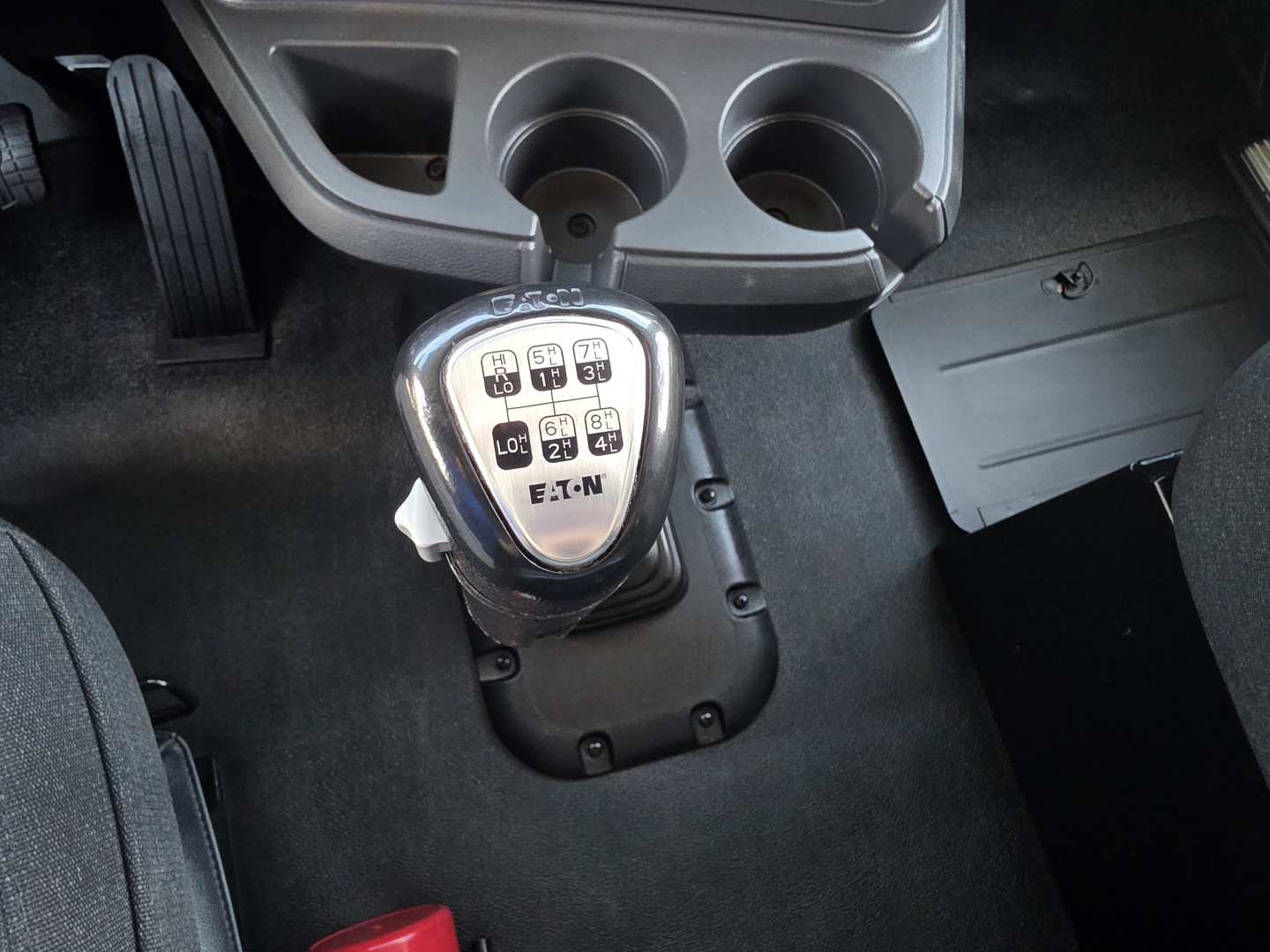Kenworth T880 interior with gear shifter and cup holders showing shift pattern.