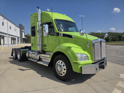 Kenworth T880 tractor in lime green, front three-quarter view showing chrome grille, exhaust stacks, dual rear axles, and side fuel tanks.