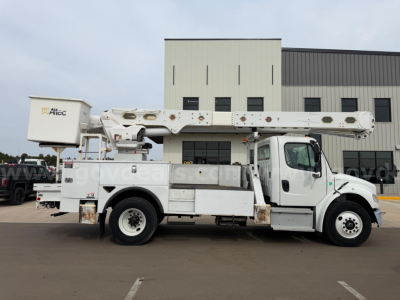 Freightliner Altec AM55 bucket truck in-service side view showing boom and utility body with stabilizers.