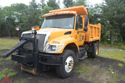 International WorkStar 7300 dump truck in-service showing front-mounted snowplow and dump bed with TD614 label