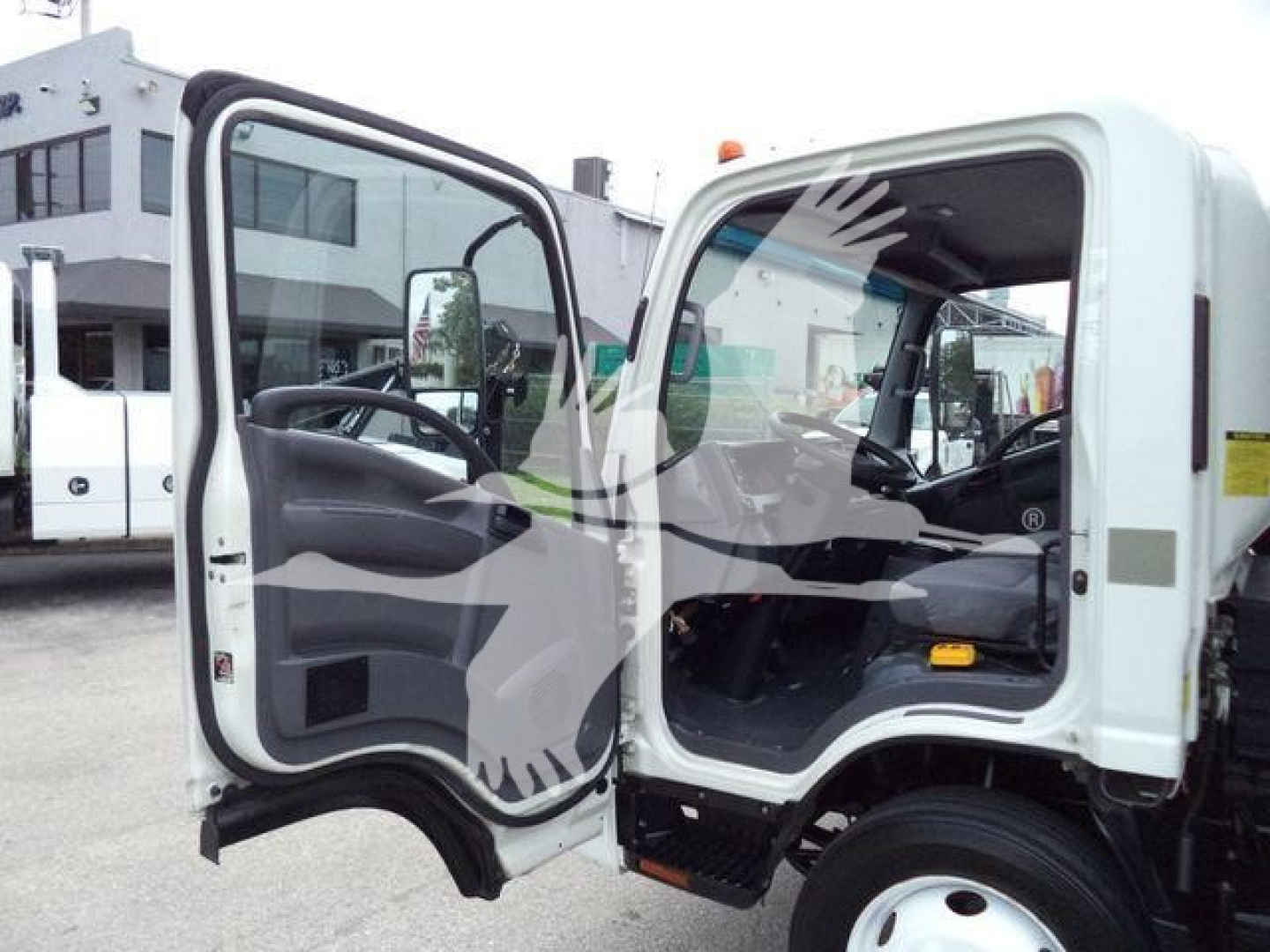 Isuzu NPR-HD cab interior with driver door open showing steering wheel dashboard and entry area.