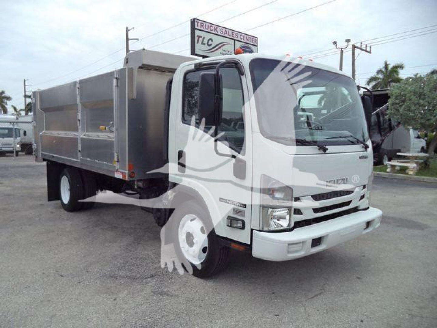 Isuzu NPR HD dump truck showing cargo bed and front grille with headlights and side mirrors.
