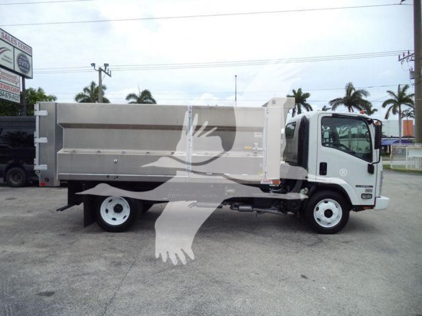 Isuzu NPR HD dump truck side view showing cargo bed and cab with Isuzu logo, stock number T00157FM visible.