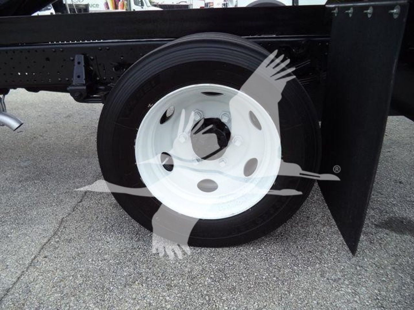 Isuzu NPR HD truck rear wheel and chassis with white steel rim and black tire.