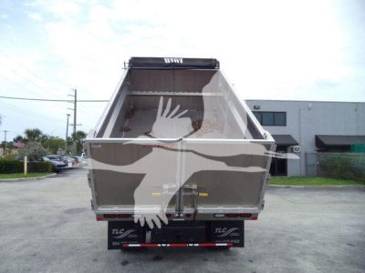 Dump body of a 2019 Isuzu NPR HD dump truck viewed from rear showing empty bed and tailgate with hydraulic mechanism.