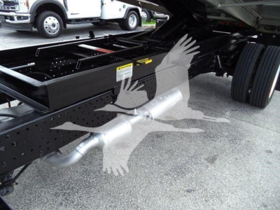 Isuzu NPR-HD truck chassis side view showing exhaust pipe and undercarriage with frame rails and dual rear wheels.