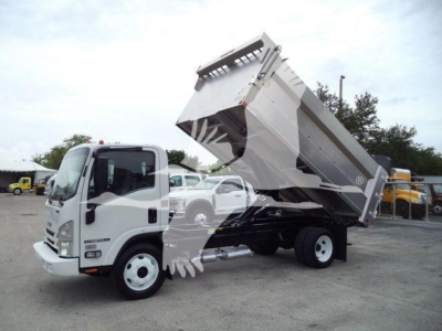 Isuzu NPR HD dump truck in-service showing hydraulic dump bed raised mid-dump with cab and front wheels visible.