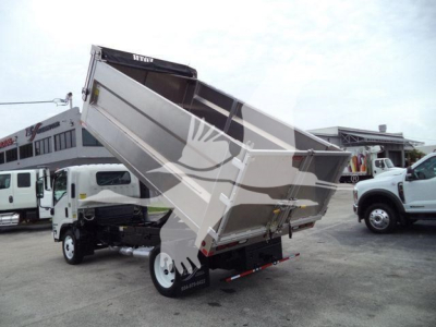Isuzu NPR HD dump truck with bed partially raised, rear view showing hydraulic lift and dual rear wheels.